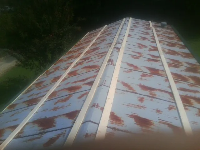 Rusted metal roof panels with new wood purlins before replacement — Storm Damage Roof Repair in Upsala by Roofing Brothers