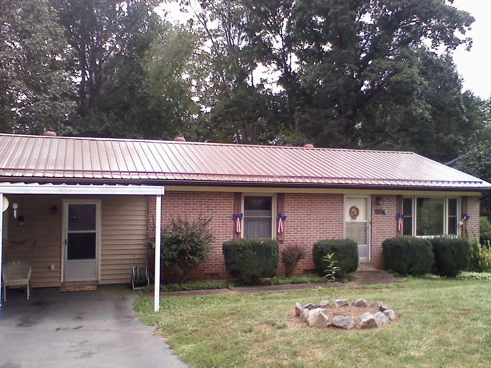 Bronze metal roof and carport on a brick ranch home — Roof Repair work by our crew in Upsala